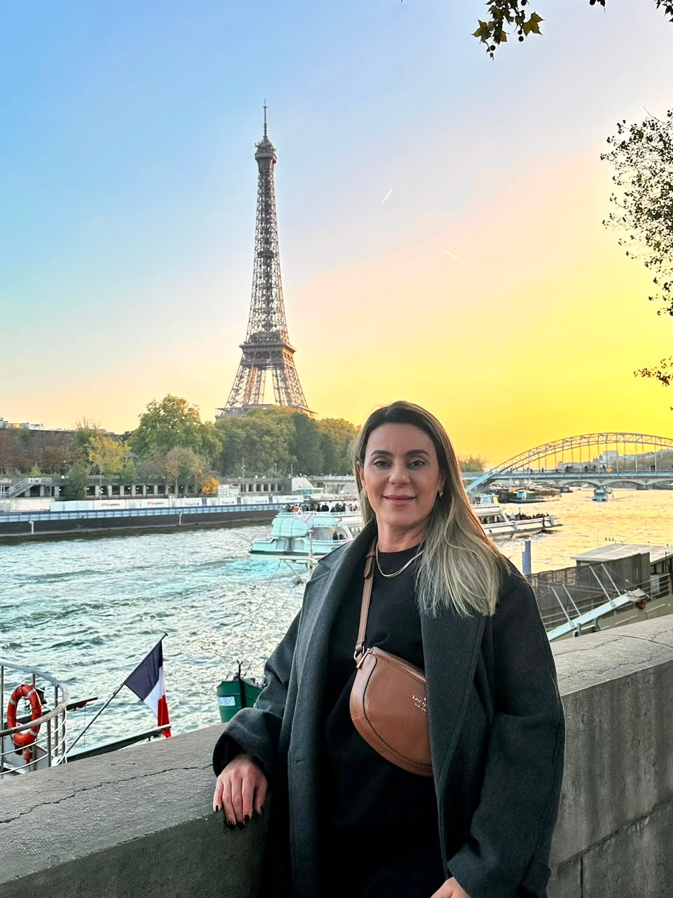 Carolina Andrade às margens do Sena com a Torre Eiffel ao fundo, em Paris